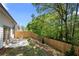 Private backyard featuring a concrete patio, wooden fence, and lush green trees at 2617 Cacao Sq, Acworth, GA 30101