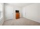 A carpeted bedroom with two white doors, one window with blinds and a wood dresser with a small TV on top at 2617 Cacao Sq, Acworth, GA 30101