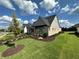 Manicured front lawn with brick and siding exterior and mature trees offers charm and curb appeal at 3220 Montebello Pkwy, Cumming, GA 30028