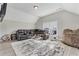 Spacious bonus room featuring hardwood floors, a large sectional sofa, and stylish decor for leisure and entertainment at 3220 Montebello Pkwy, Cumming, GA 30028