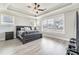 Spacious main bedroom with tray ceiling, natural light, hardwood floors, and dark wood furniture at 3220 Montebello Pkwy, Cumming, GA 30028