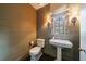 Stylish powder room with a pedestal sink, paneled walls, and decorative lighting at 728 Wesley Nw Dr, Atlanta, GA 30305