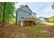 View of a blue two-story house, showcasing a wooden deck and fenced backyard at 1697 Ramblewood Way, Snellville, GA 30078