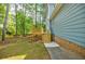 A large backyard featuring a wooden deck with steps down to a grassy, partially shaded lawn at 1697 Ramblewood Way, Snellville, GA 30078