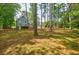 Spacious backyard featuring a well-maintained lawn, mature trees, shed, and a deck at 1697 Ramblewood Way, Snellville, GA 30078