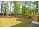 The large backyard features mature trees, well-maintained lawn, and a wooden deck at 1697 Ramblewood Way, Snellville, GA 30078