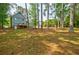 The large backyard features mature trees, lawn, a wooden deck, and blue siding at 1697 Ramblewood Way, Snellville, GA 30078