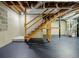 Unfinished basement featuring stairs to the upper level and a painted cement floor at 1697 Ramblewood Way, Snellville, GA 30078