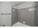 Bathroom features a combination tub and shower with gray tiling at 1697 Ramblewood Way, Snellville, GA 30078