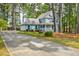 A beautiful two-story home with a long driveway, attached garage, and mature trees surrounding the property at 1697 Ramblewood Way, Snellville, GA 30078