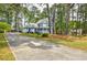 A beautiful two-story home with a long driveway, attached garage, and mature trees surrounding the property at 1697 Ramblewood Way, Snellville, GA 30078