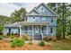 Charming two-story home with a covered front porch, manicured landscaping, and light blue siding at 1697 Ramblewood Way, Snellville, GA 30078