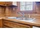 Close-up of kitchen sink and window area showcasing wood cabinets and stainless steel sink at 1697 Ramblewood Way, Snellville, GA 30078