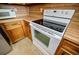 Close-up of white oven and range appliances surrounded by wood kitchen cabinets at 1697 Ramblewood Way, Snellville, GA 30078