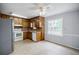 Kitchen featuring wood cabinets, white appliances, and a large window overlooking the backyard at 1697 Ramblewood Way, Snellville, GA 30078