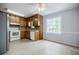 Kitchen featuring wood cabinets, white appliances, and a bright window overlooking the backyard at 1697 Ramblewood Way, Snellville, GA 30078