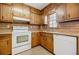 Close-up of the kitchen area showcasing wood cabinets, white appliances, and a bright window at 1697 Ramblewood Way, Snellville, GA 30078