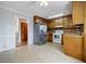 Kitchen featuring wood cabinets, white appliances, and easy access to other rooms at 1697 Ramblewood Way, Snellville, GA 30078
