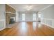 Bright living room with gleaming hardwood floors, and a cozy fireplace with windows for natural light at 1697 Ramblewood Way, Snellville, GA 30078