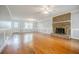 Expansive living room with hardwood floors, a brick fireplace, and natural light from large windows at 1697 Ramblewood Way, Snellville, GA 30078