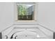 Bathroom featuring a large soaking tub under a window at 2075 Villa Spring Ct, Dacula, GA 30019