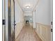 Inviting hallway featuring wood floors and decorative wall paneling, leading to a cozy living space at 2075 Villa Spring Ct, Dacula, GA 30019