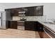 Stylish kitchen featuring stainless steel appliances, dark cabinets, and granite counters at 2075 Villa Spring Ct, Dacula, GA 30019