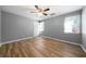 Spacious bedroom with modern ceiling fan, two windows, and stylish laminate flooring at 30 Village Dr, Cartersville, GA 30121