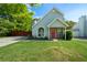 Charming home featuring a red door, arched window, and well-manicured lawn at 30 Village Dr, Cartersville, GA 30121