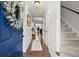 Welcoming foyer with hardwood floors, a charming wreath, and a staircase leading to the upper level at 3065 Camden Way, Alpharetta, GA 30005