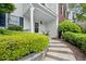 Inviting front entrance featuring a well-maintained lawn with shrubbery and a gray exterior with black shutters at 3065 Camden Way, Alpharetta, GA 30005