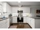 Modern kitchen featuring white cabinets, stainless steel appliances, granite countertops, and hardwood floors at 3065 Camden Way, Alpharetta, GA 30005