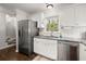 Modern kitchen with stainless steel appliances, granite countertops, white cabinets, and hardwood floors at 3065 Camden Way, Alpharetta, GA 30005