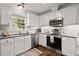 Bright kitchen with white cabinets, stainless steel appliances, granite countertops, and hardwood floors at 3065 Camden Way, Alpharetta, GA 30005
