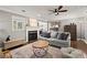 A cozy living room with a fireplace, grey sofa and a ceiling fan creating a warm and inviting atmosphere at 3065 Camden Way, Alpharetta, GA 30005