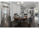 Open-concept dining area featuring a round table, with an adjacent modern kitchen, and view of the hallway at 408 Cottonwood Cir, Peachtree City, GA 30269