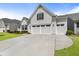 Bright home featuring a wide driveway, an attached two car garage, and a well-manicured lawn at 408 Cottonwood Cir, Peachtree City, GA 30269