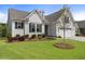 Inviting home with manicured lawn, landscaped garden bed, and an attached two car garage at 408 Cottonwood Cir, Peachtree City, GA 30269