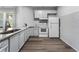 Well-lit kitchen with white cabinets, stainless steel appliances, and gray wood floors at 408 Cottonwood Cir, Peachtree City, GA 30269