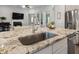 Granite island countertop features a stainless sink with living area views in a modern open concept living space at 408 Cottonwood Cir, Peachtree City, GA 30269