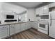 Open-concept kitchen with granite countertops, white cabinetry, and gray wood flooring at 408 Cottonwood Cir, Peachtree City, GA 30269