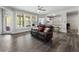 An open-concept living room with a brown leather sofa, wood-look flooring, and a bright window at 408 Cottonwood Cir, Peachtree City, GA 30269