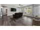Living area features a brown leather sofa, ceiling fan, and a window with natural light at 408 Cottonwood Cir, Peachtree City, GA 30269