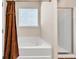 Bright bathroom features a tub with shower and separate shower stall with glass door at 637 Sunflower Dr, Canton, GA 30114