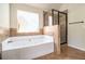 Bright bathroom featuring a shower and jetted tub near a window at 640 Parkside Place Dr, Mcdonough, GA 30253