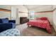 Stylized bedroom features orange and gray accent stripes, a comfy chair, and natural light from the window at 640 Parkside Place Dr, Mcdonough, GA 30253