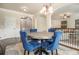 A dining room with hardwood floors, an area rug, a table with blue chairs, and white trim at 640 Parkside Place Dr, Mcdonough, GA 30253