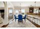 A dining room with hardwood floors, an area rug, a table with blue chairs, and white trim at 640 Parkside Place Dr, Mcdonough, GA 30253