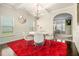 Bright and airy dining room featuring a round table, stylish chandelier, and a vivid red rug that enhances the space at 640 Parkside Place Dr, Mcdonough, GA 30253