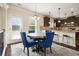 A dining room with hardwood floors, an area rug, a table with blue chairs, and a bar with stools at 640 Parkside Place Dr, Mcdonough, GA 30253